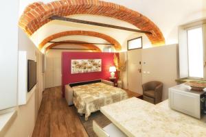 アルバにあるAppartamento San Giuseppeの赤い壁のベッドルーム1室(ベッド1台付)
