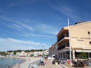 ein Gebäude an einem Strand neben dem Wasser in der Unterkunft Hotel Chanteplage in Saint-Cyr-sur-Mer