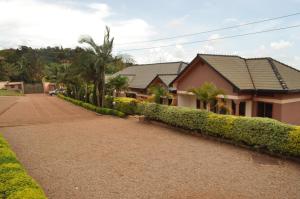 una casa con árboles y arbustos junto a una entrada en Kd Apartments Mediterranean Village, en Kampala