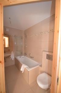 ein Bad mit einer Badewanne und einem WC in der Unterkunft Le Nid de Martinet in Grimentz