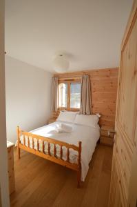 um quarto com uma cama grande e uma janela em Le Nid de Martinet em Grimentz