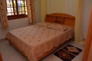 1 dormitorio con 1 cama en una habitación con ventana en Kd Apartments Mediterranean Village, en Kampala