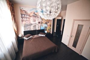 Zimmer mit einem Kronleuchter und einem Bett. in der Unterkunft Weekend в ЦЕНТРЕ рядом с ЖД ВОКЗАЛОМ in Krasnojarsk