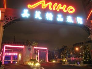 a neon sign for a hotel at night at Miho Boutique Motel in Zhonghe