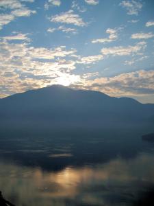 um pôr-do-sol sobre a água com uma montanha ao fundo em Taiwan Beauty Hotel - Sun Moon Lake em Yuchi