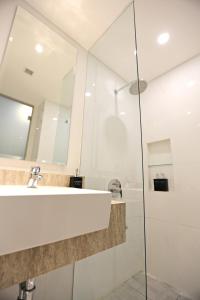 bagno con lavandino e specchio di Luminor Hotel Jambi Kebun Jeruk By WH a Jambi