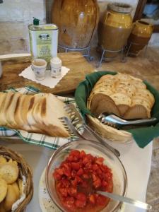 a table topped with bread and a bowl of tomatoes at Masseria Asciano in Ostuni