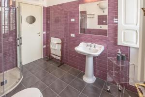 a purple tiled bathroom with a sink and a shower at Le Petit Relais in Viterbo