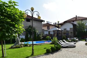 a yard with lounge chairs and a swimming pool at Complex Oazis in Etropole