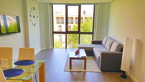 a living room with a couch and a table at Apartamento Boulevard Gran Capitan by JITKey in Córdoba