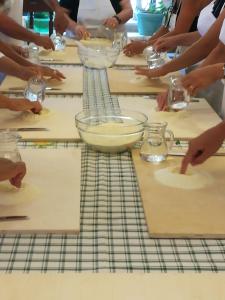 a group of people sitting around a table preparing food at Masseria Asciano in Ostuni