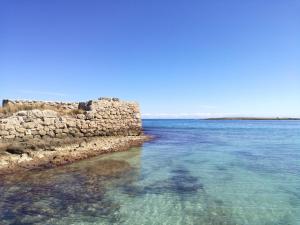 a view of the water near a stone wall at Masseria Asciano in Ostuni