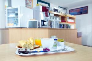 taca z jedzeniem z chlebem i napojami na stole w obiekcie Premiere Classe Freyming Merlebach w mieście Freyming