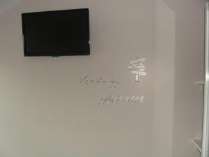 a wall with a tv and a drawing of a glass of wine at Chambres d'hôtes Sébastien in Ruaudin