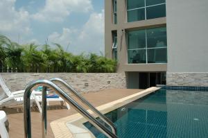 una piscina junto a un edificio con una casa en Bangkok Living, en Bangkok