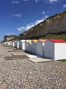 Une rangée de cabanes de plage sur une plage rocheuse dans l'établissement Villa Fleurs de France, à Criel-sur-Mer