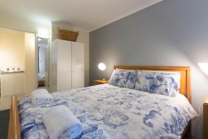 a bedroom with a blue and white bed with two pillows at Inner City Apartments Hotel in Perth