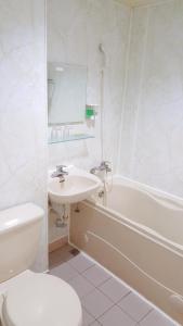 a bathroom with a sink and a toilet and a tub at Rui Gu Hotel in Kaohsiung