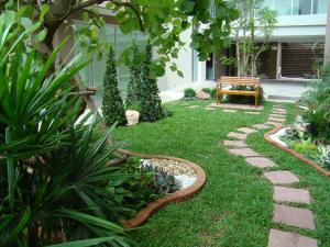 un jardín con un sendero de piedra y un banco en Bangkok Living, en Bangkok