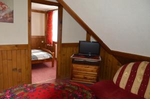 a room with a staircase with a tv and a bed at Willa Janosik in Witów