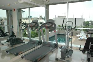 un gimnasio con varias máquinas de correr en una habitación con ventanas en Bangkok Living, en Bangkok