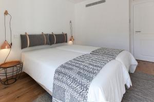 リスボンにあるFLH Restauradores Luxus Flatのベッドルーム(白黒の毛布付きベッド1台付)