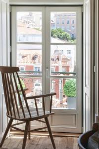 リスボンにあるFLH Restauradores Luxus Flatの窓際に座る木製椅子