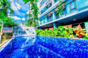 a swimming pool in front of a building at Tree Boutique Residence - Quiet Oasis - Stunning View, Pool & Gym in Chiang Mai