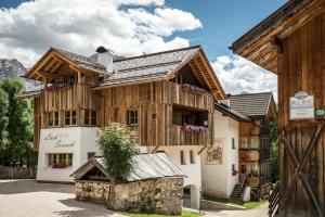 un edificio de madera con un árbol encima en Natur Luch Sossach, en La Villa