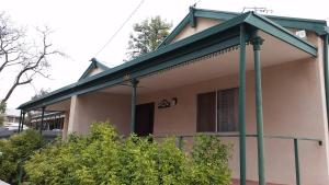 una casa con un tetto verde sopra di essa di About Town Cottages a Broken Hill
