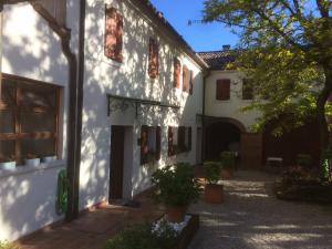 a white building with red windows and a courtyard at Locanda Stella D'oro in Quinto di Treviso