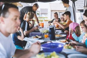 a group of people sitting around a table eating food at Vakantiedorp Marinapark in Westende