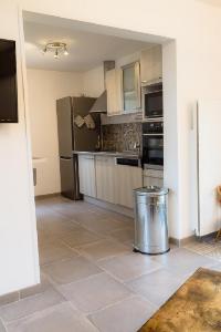 a kitchen with stainless steel appliances and a tile floor at Gite Des Peupliers in Girondelle