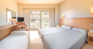 a bedroom with two beds and a desk and a television at Hotel RH Gijón & Spa in Gandía +22 photos