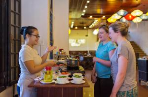 a group of women standing around a table with food at Hoi An Hai Au Boutique Hotel in Hoi An