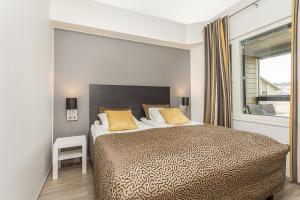 Un dormitorio con una cama grande y una ventana en Holiday Club Himos Superior Apartments en Jämsä