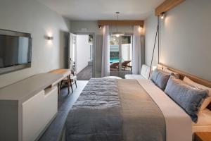 a bedroom with a large bed and a desk at Meltemi Excelsior Suites in Perissa +43 photos