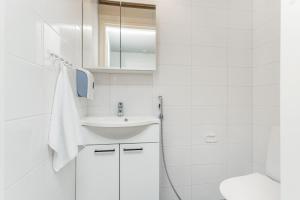 a white bathroom with a sink and a toilet at Holiday Club Himos Superior Apartments in Jämsä +11 photos