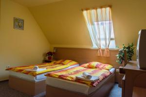 A bed or beds in a room at Turul Étterem és Panzió