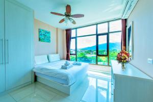 a bedroom with a bed and a large window at Tree Boutique Residence - Quiet Oasis - Stunning View, Pool & Gym in Chiang Mai +33 photos