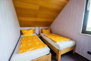 two beds in a small room with yellow pillows at Haus Fernblick in Bad Grund