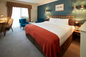 um quarto de hotel com uma cama grande e uma secretária em Hotel Cromwell Stevenage em Stevenage