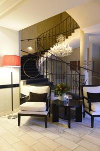 a living room with a chandelier and a staircase at Clarion Collection Hotel Smedjan in Sandviken
