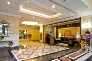 a lobby with a piano and a checkerboard floor at LK Royal Suite in Pattaya