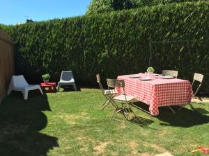 - une table et des chaises rouges et blanches dans la cour dans l'établissement Coeur des Domes, à Fontfreide