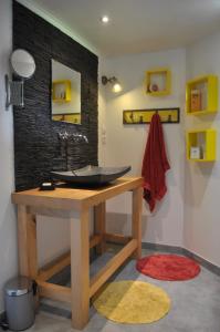 La salle de bains est pourvue d'un lavabo sur une table en bois. dans l'établissement Coeur des Domes, à Fontfreide