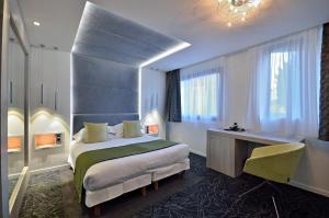 um quarto de hotel com uma cama e uma secretária em Cézanne Hôtel Spa em Cannes