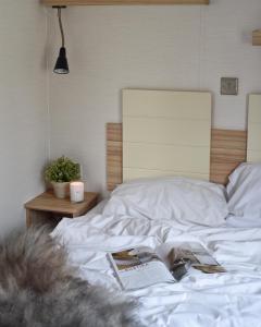 Una cama blanca con un libro encima. en Valfjället Ski center en Gryttved