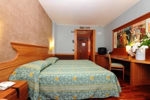 A bed or beds in a room at BV Grand Hotel Assisi