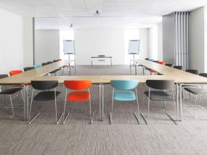 une salle de conférence avec une grande table et des chaises dans l'établissement Ibis Wavre Brussels East, à Wavre